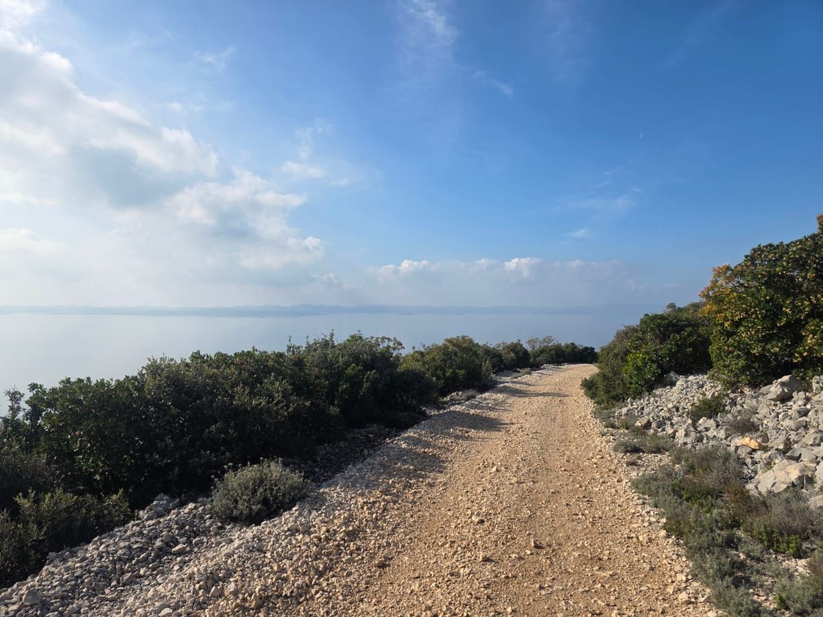 Gravel-Biker bei Reparatur in kroatischer Landschaft