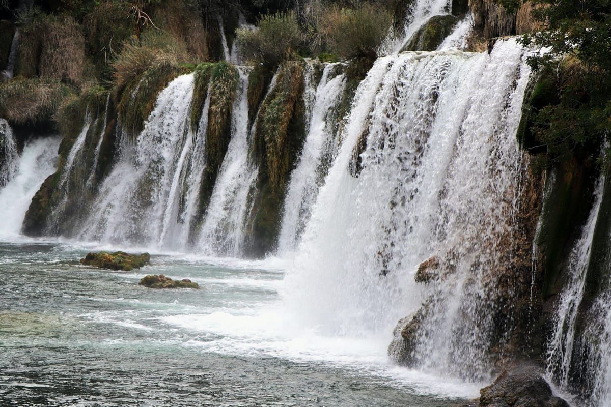 Eine Firmengruppe wandert über die Holzstege am Wasserfall Skradinski buk im Krka-Nationalpark