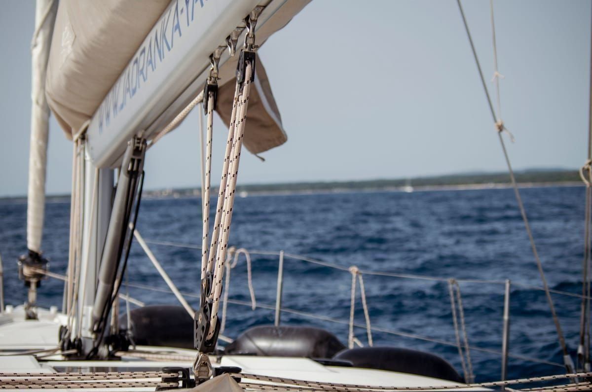 Segelboot in einer Bucht der Kvarner-Inseln mit klarem türkisfarbenem Wasser