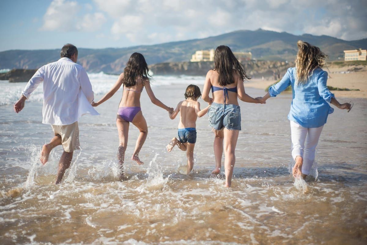Familie mit Schwimmreifen am Eingang eines Wasserparks am Morgen