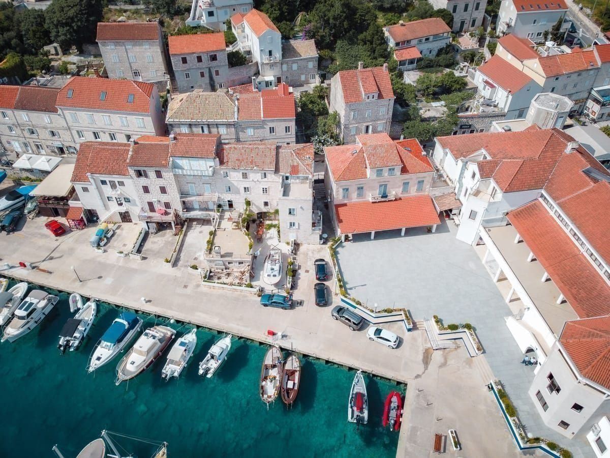 Hafen von Prvić Luka mit Booten und Steinhäusern am Ufer