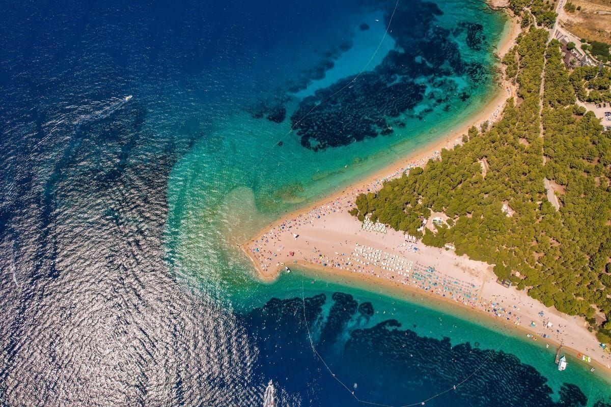 Kiesstrand mit türkisem Wasser auf einer Insel vor Šibenik