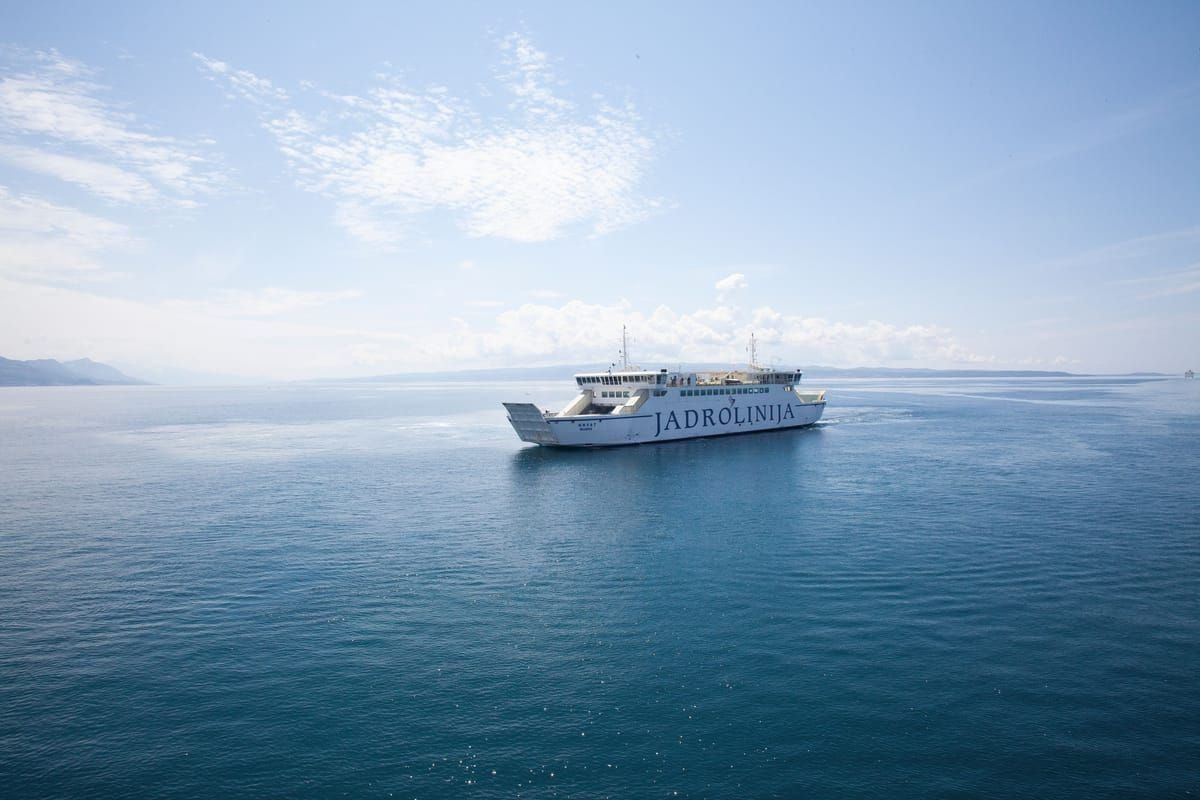 Steinhäuser und Kirchturm im Hauptort von Zlarin am Wasser