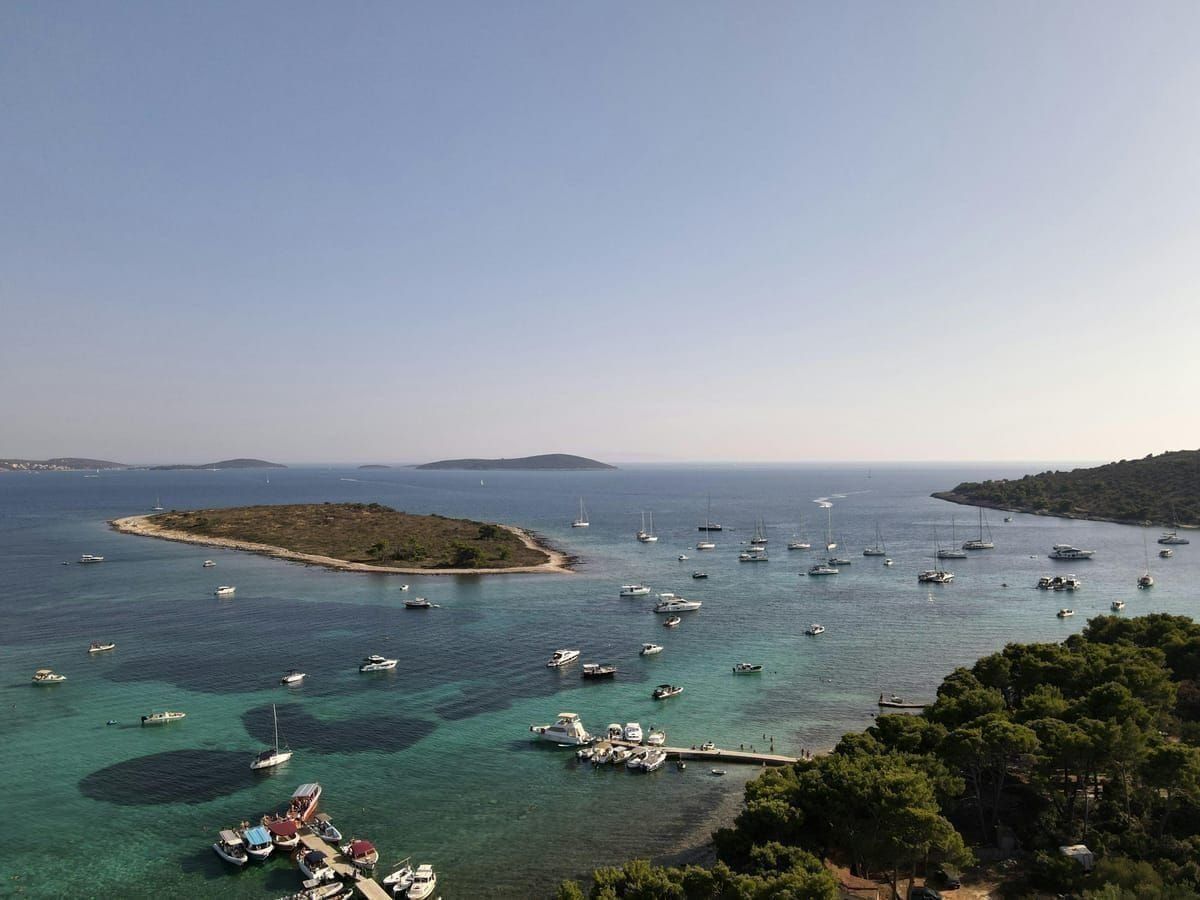 Pastellfarbene Hafenbucht von Veli Lošinj mit kleinen Booten und Steinhäusern