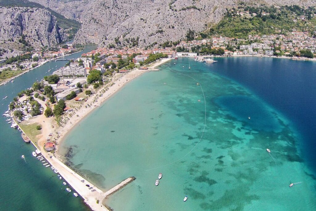 Der lange Sandstrand Velika Plaza in Omiš mit Bergkulisse
