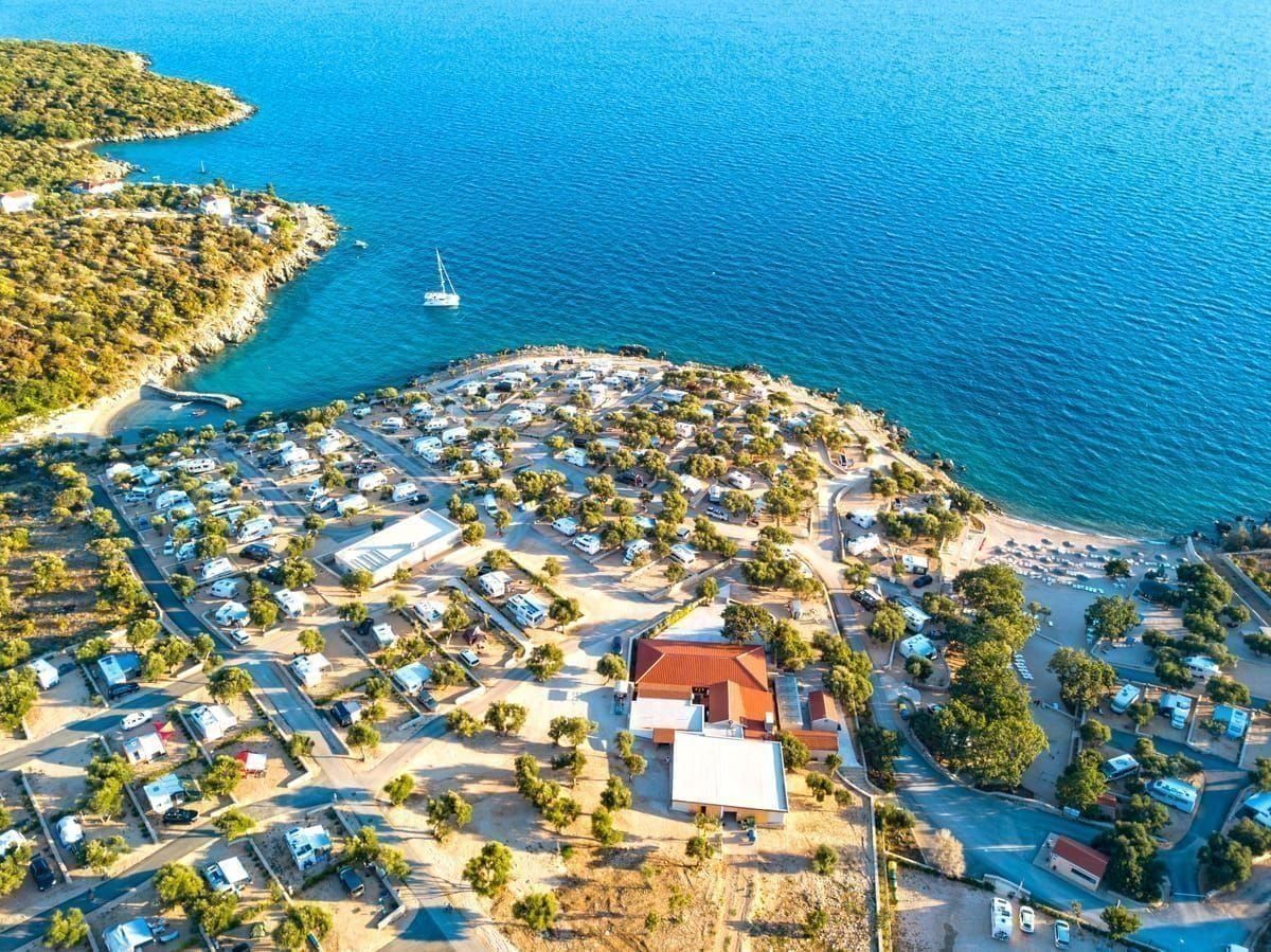 Glamping-Zelt mit Holzdeck zwischen Pinien an der kroatischen Küste