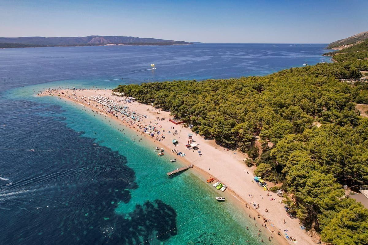 Familie spaziert entlang einer Strandpromenade mit Palmen in Dalmatien