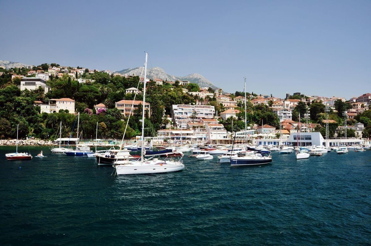 Küstenort auf der Insel Krk mit Hafen und Bergen im Hintergrund