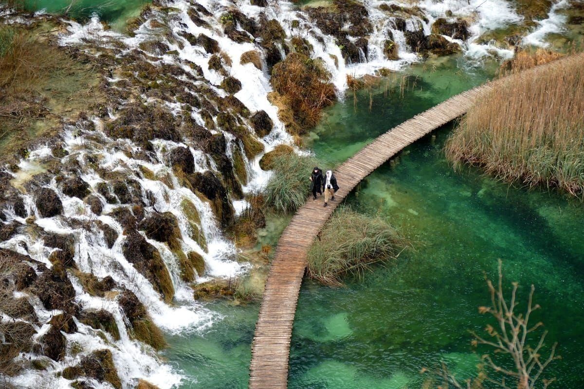 Holzstege über türkisfarbenem Wasser im Nationalpark Plitvicer Seen im Herbst