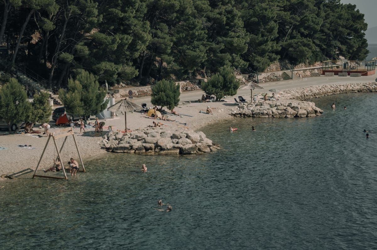 Sonnenschirm und Liegen an einem kroatischen Strand in der Mittagshitze