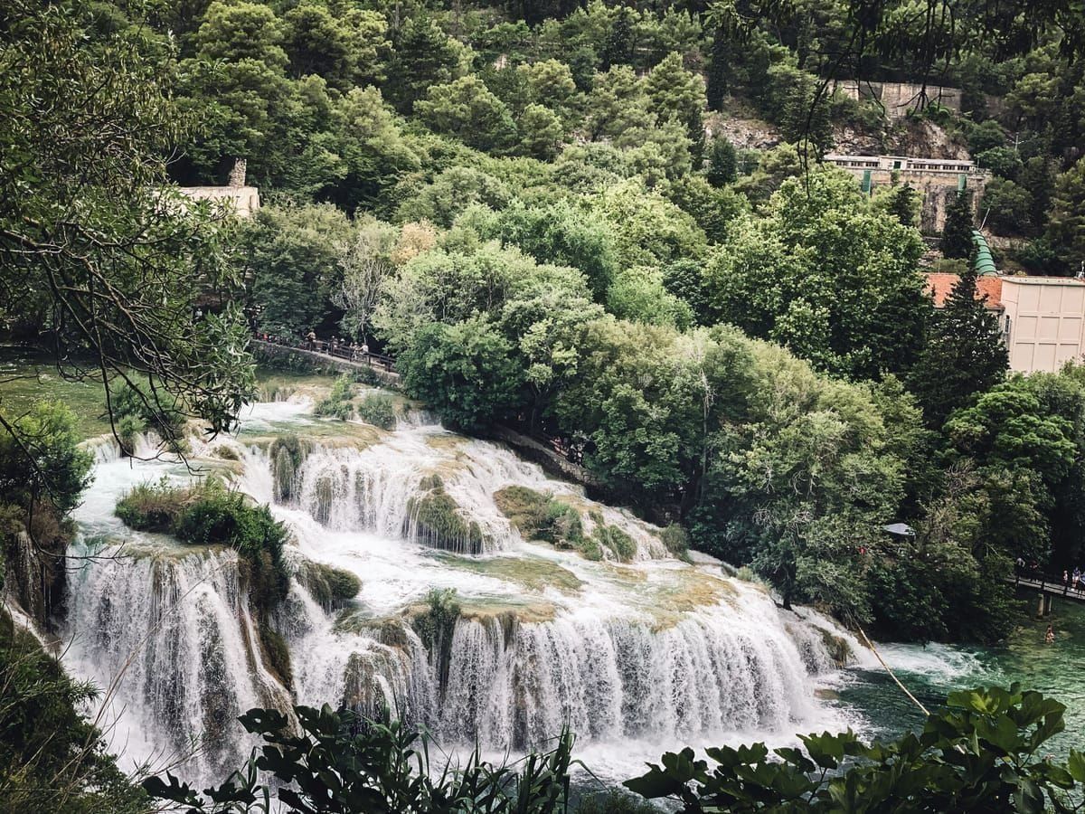 Der Skakavac-Wasserfall stürzt über moosbewachsene Felsen im Wald
