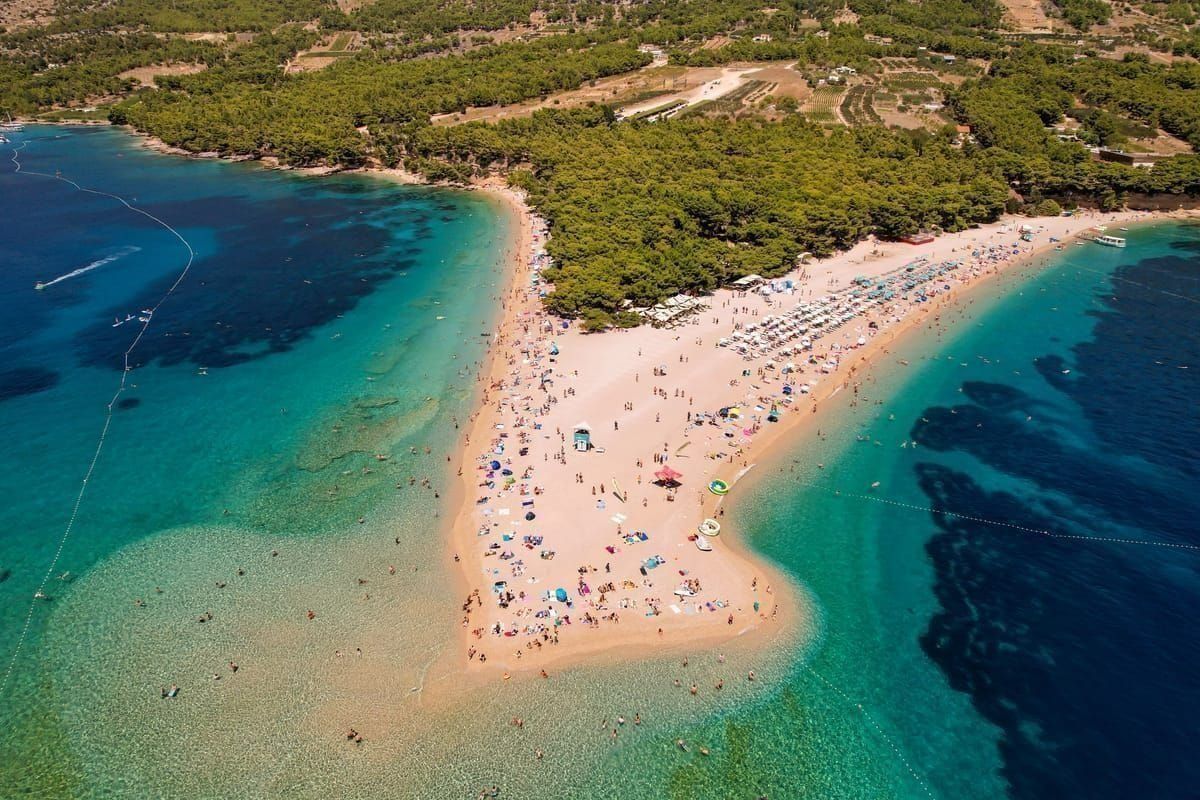 Windsurfer im türkisen Wasser vor der Küste von Bol auf Brač