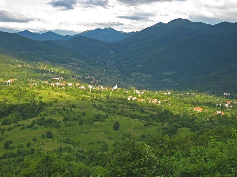 Altes Dorfhaus und Holzstapel im Bergdorf Kuterevo